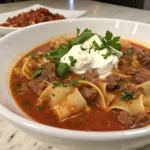 Beef sausage lasagna soup topped with a dollop of ricotta cheese.