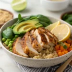 Bowl of sliced chicken, sweet potatoes, and spinach on quinoa.